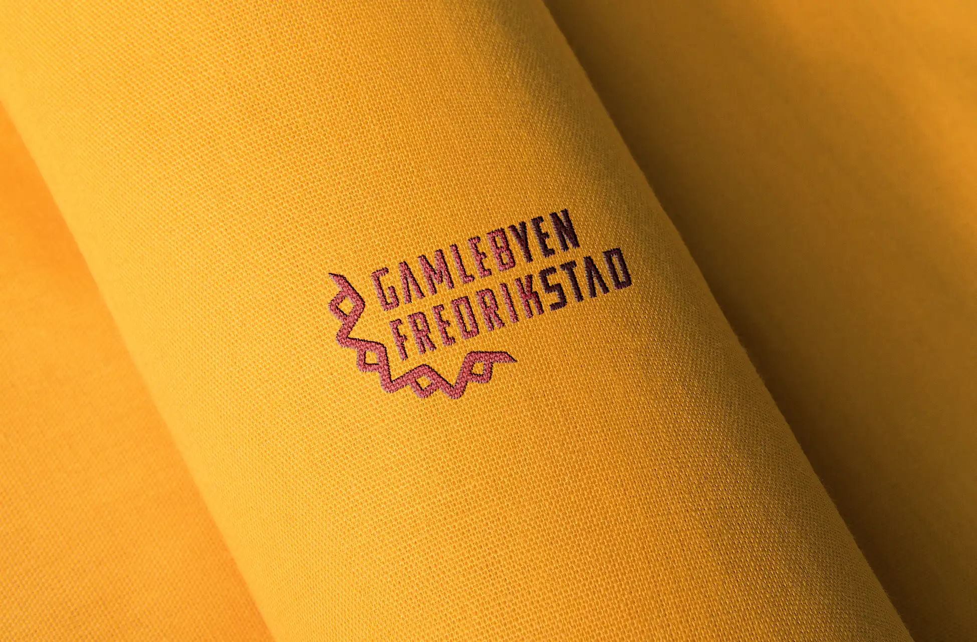 Logoen for Gamlebyen Fredrikstad brodert på tekstil